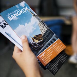 Closeup of hand holding Bangkok travel guide brochure